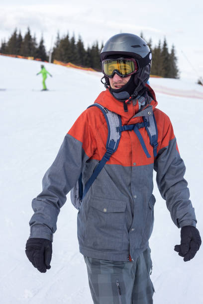 Snowboarder moves down the ski slope. Rest in a ski resort. Young man moves down a ski slope on a snowboard. bukovel ski resort ukraine stock pictures, royalty-free photos & images