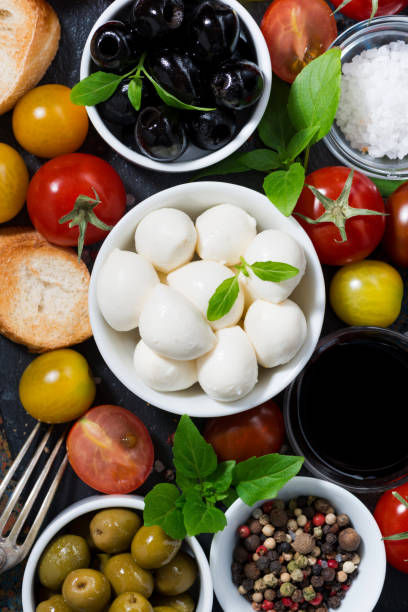istock mozzarella, fresh ingredients for the salad and bread, vertical, top view 1153809911
