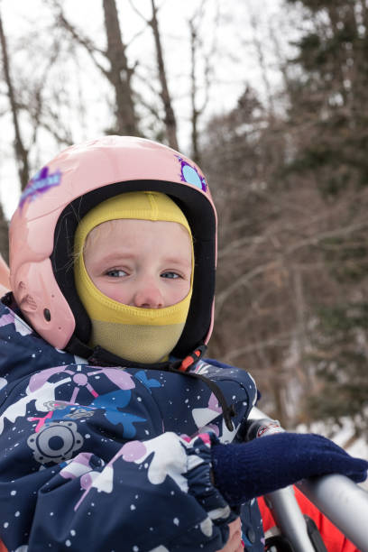Child in a ski suit on a ski lift. Portrait of a child who rises up on the ski lift to the top of the mountain. bukovel ski resort ukraine stock pictures, royalty-free photos & images