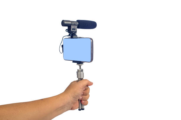 istock streaming video live with smart phone and microphone tool in hand. 1153814714