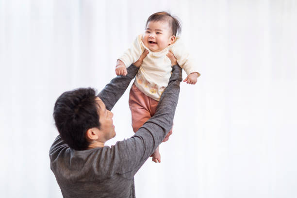 istock She is lifted up by her dad and laughs. 1153816836
