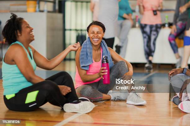 Friends Sitting On The Floor And Talking After Dance Class While Drinking Water Stock Photo - Download Image Now