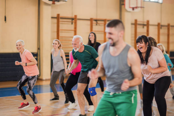 Smiling and happy group of people dancing at gym Smiling and happy group of people dancing at gym community health center stock pictures, royalty-free photos & images