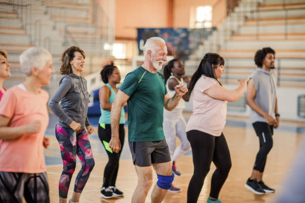 große gruppe von menschen, die in der zumba-klasse tanzen - menschliche statur stock-fotos und bilder