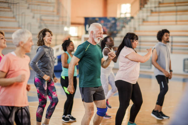 Large group of people dancing at Zumba class Large group of people dancing at Zumba class exercise class photos stock pictures, royalty-free photos & images