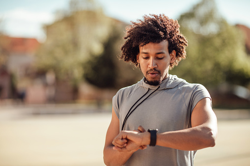 Young sportsman looking at fitness tracker