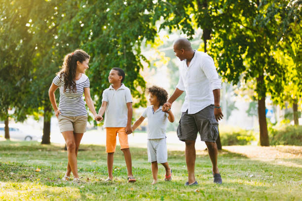 istock Happy couple spending time with their sons in park 1153820446