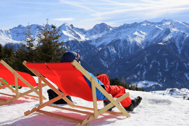 skier enjoying the nice weather in the deck chair - ski skiing european alps resting imagens e fotografias de stock