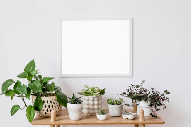istock Stylish scandinavian interior with mock up poster frame, design bamboo commode and beautiful composition of plants in different hipster pots. Modern home decor. Minimalistic concept. Home garden. 1153823765