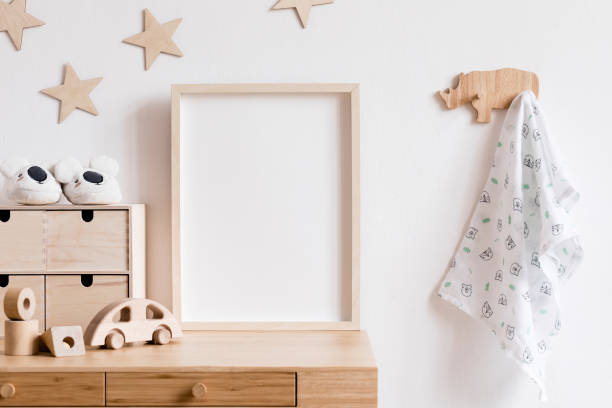 elégant scandi salle de réunion avec maquette en bois cadre photo, jouets en bois, boîtes, blocs et accessoires motif étoiles sur le mur de fond. intérieur lumineux et ensoleillé avec bureau en bois. décor à la maison. - chambre de bébé photos et images de collection