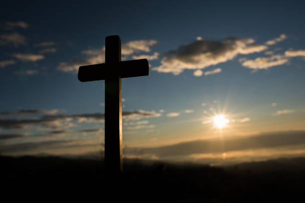 istock Silhouette of catholic cross and sunrise 1153827762