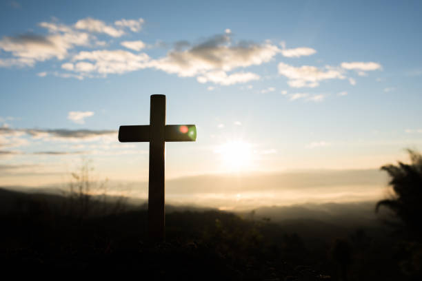 istock Silhouette of catholic cross and sunrise 1153828038