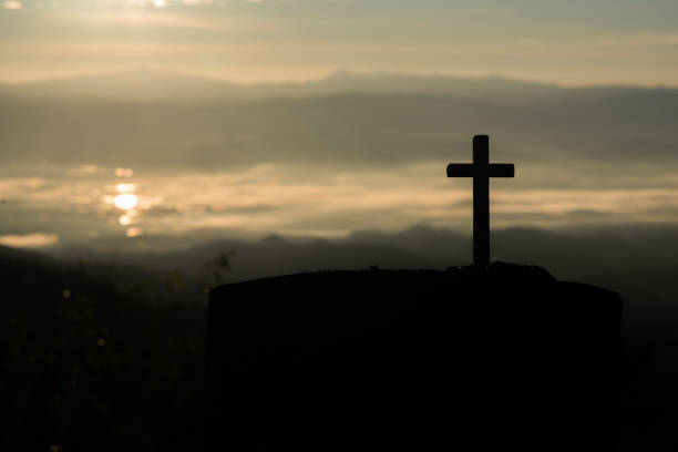 istock Silhouette of catholic cross and sunrise 1153829134