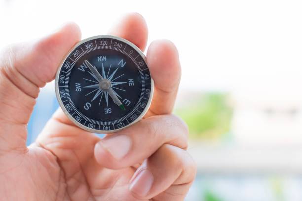 istock man holding compass on blurred background. for activity lifestyle outdoors freedom or travel tourism and inspiration backpacker alone tourist travel or navigator image. 1153833957