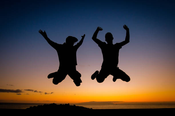 istock Silhouette Of People Jumping Against Sky During Sunset 1153833963