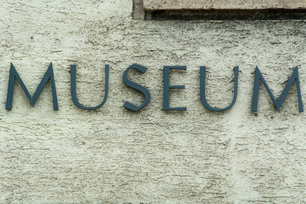 istock Weathered metal museum sign on plaster wall 1153834234