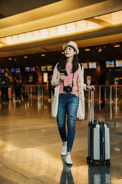 istock asian female looking for the flight information. 1153839129