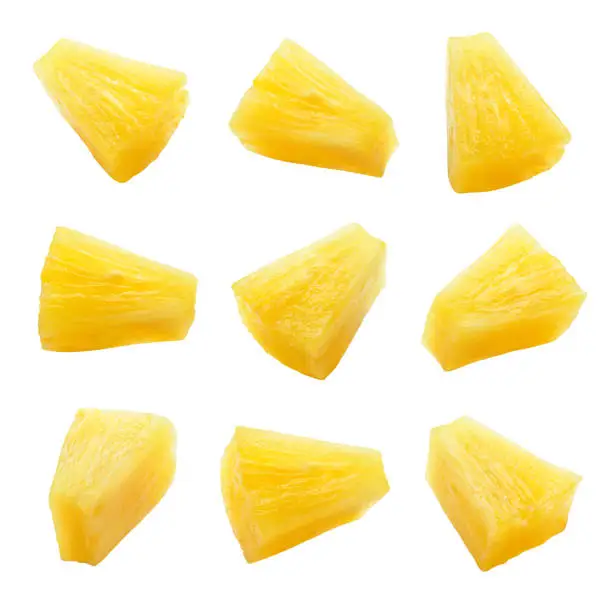 Photo of Canned pineapple chunks. Pineapple slices isolated. Set of pineapple chunks. Clipping path.