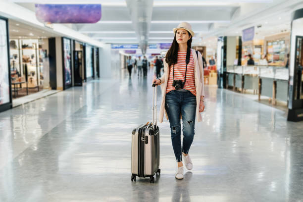 istock lady with suitcase walk in duty free store 1153839529