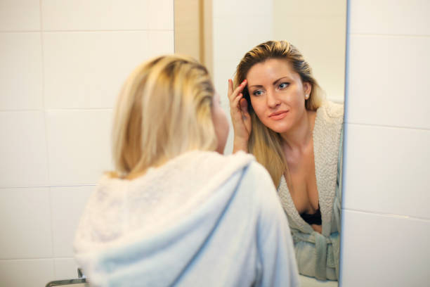 istock Young woman looking in the mirror 1153843068