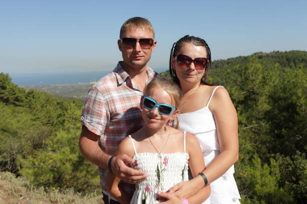 Family is posing on valley background on Rhodes, Greece