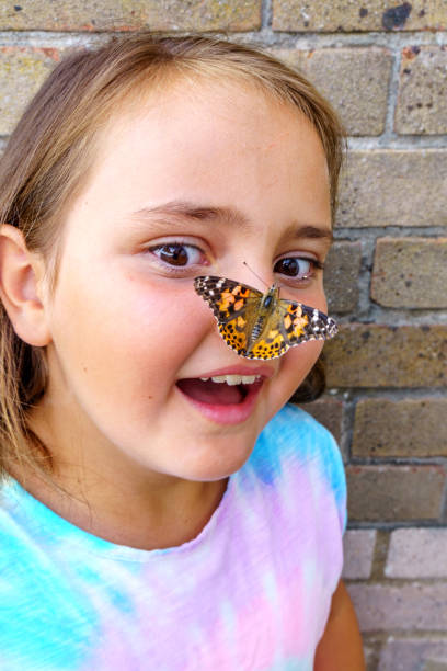 istock Ten year old girl with butterfly on her nose 1153845724