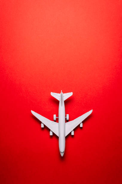 istock jet airplane travel concept, minimal art, on red background. 1153846891