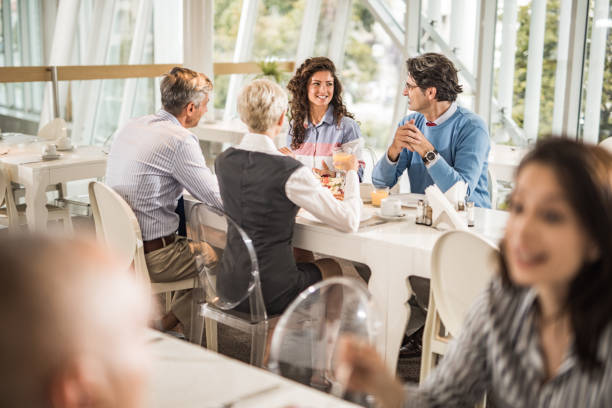 istock Happy business colleagues talking on a lunch break in cafeteria. 1153846965