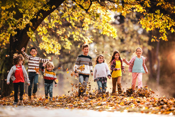 istock Playful children having fun while running in autumn day at the park. 1153849696