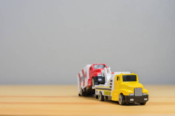 loading broken toy car on a service tow truck  on a roadside after acident on grey background.copy space - tow truck heavy truck delivering imagens e fotografias de stock