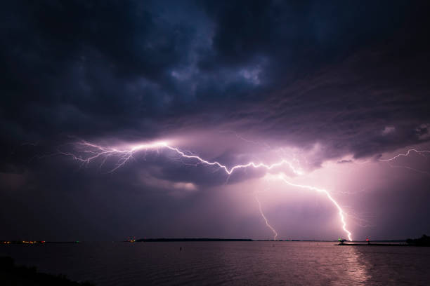 молния в темном ночном небе над озером в течение лета - global warming flash стоковые фото и изображения