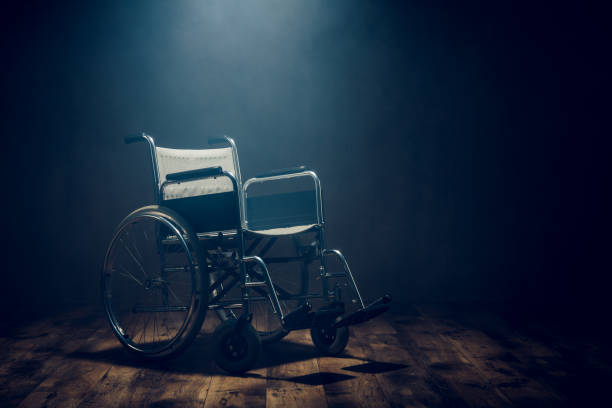 Wheelchair in empty dark room stock photo