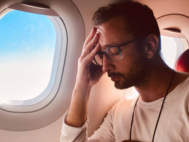 istock Tired / sick passenger in a modern airplane seat next to the window. 1153854954
