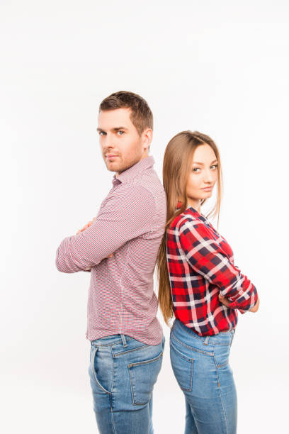 istock Couple in love  standing back to back with crossed hands 1153855021