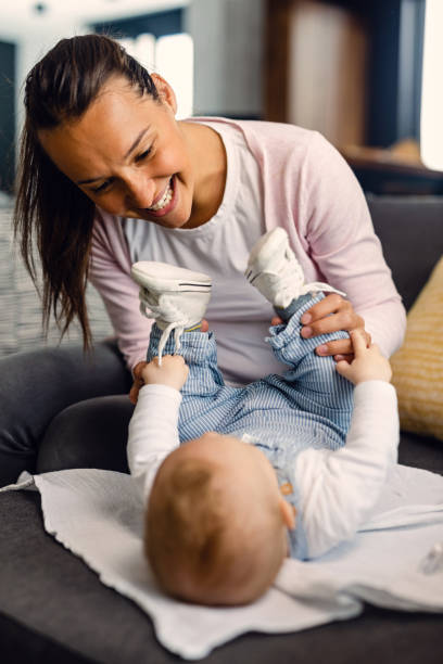 istock Young mother having fun with her baby at home. 1153856269