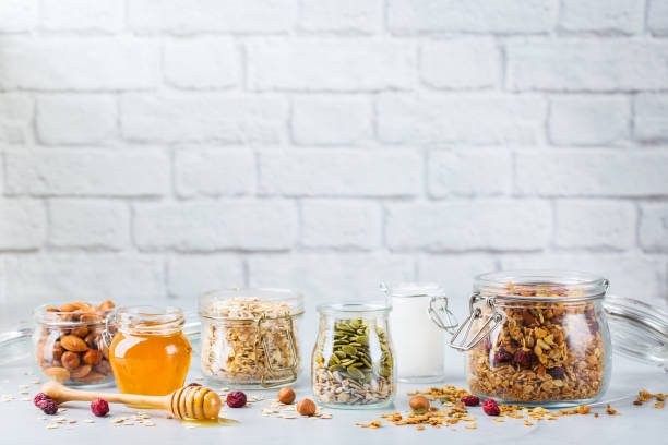 muesli caseiro do granola com ingredientes, alimento saudável para o pequeno almoço - jar oatmeal granola glass - fotografias e filmes do acervo