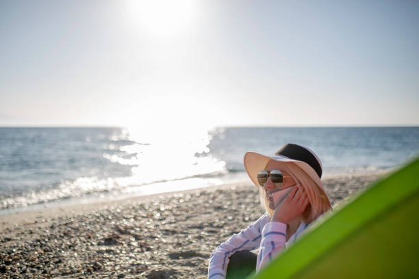 istock Woman watching sunset by the sea 1153860068