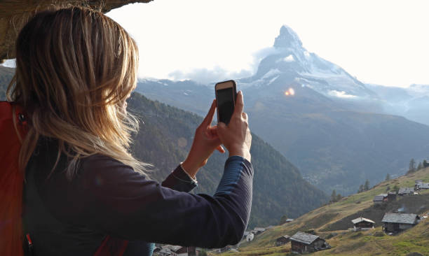 istock Young woman uses cell phone under chalet eaves 1153860961