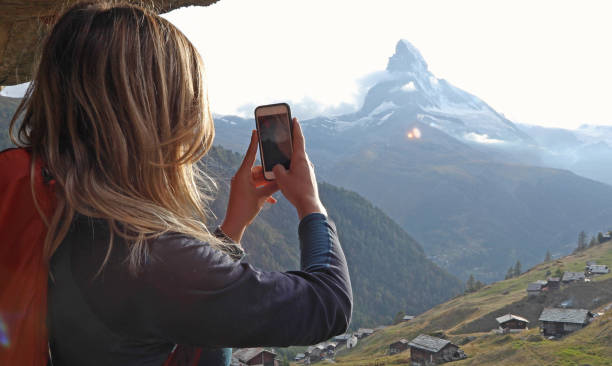 istock Young woman uses cell phone under chalet eaves 1153861029