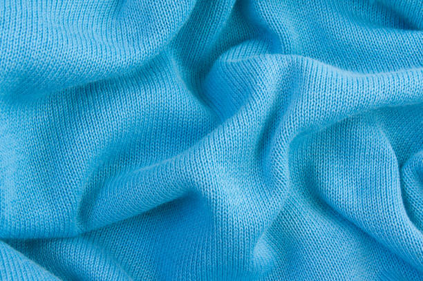 Background of crumpled blue knitted fabric, close-up, texture of knitted fabric.