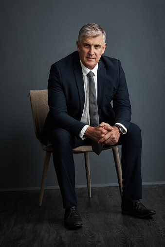 Studio shot of a mature businessman posing against a grey background