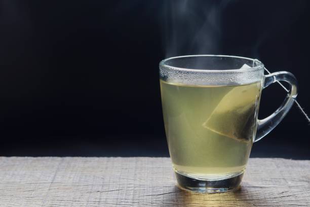 istock Hot tea in a glass on dark background 1153866061