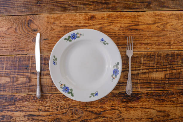 istock Empty plate with spoon and fork on wooden background. Flat lay. Place under your text. 1153867115