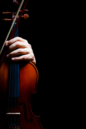 musician hand on violin, isolated on black. music background