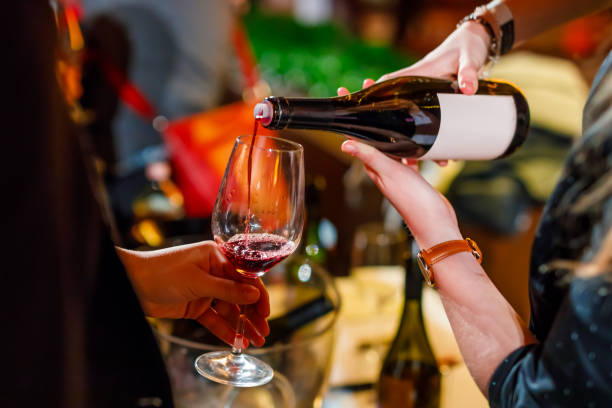 istock pouring wine from the bottle into the glass 1153868603