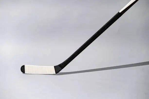 Photo of Ice hockey stick on isolated white background, equipment for hockey player in winter game season, closeup on Wooden head ice hockey stick Kevlar design.