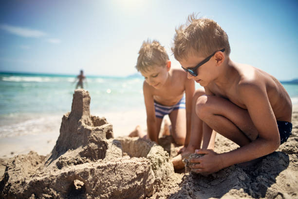 istock Little boys building a sandcastle on beach 1153878458