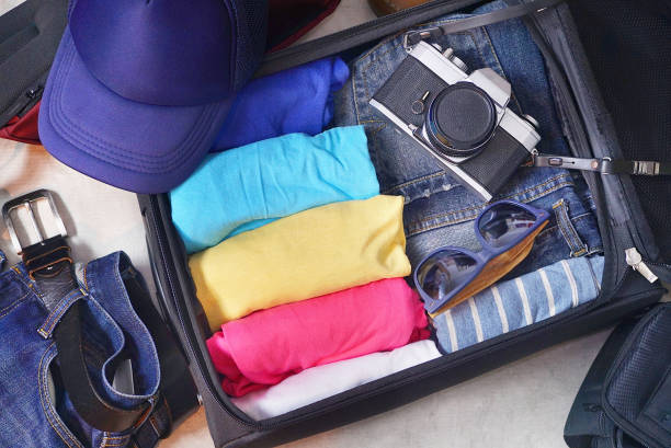 istock Topview open travel bag which have clothes and accessories. 1153884086