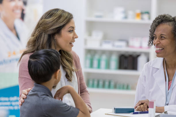 istock Mature adult pharmacist laughs at comment from Hispanic mom 1153885280