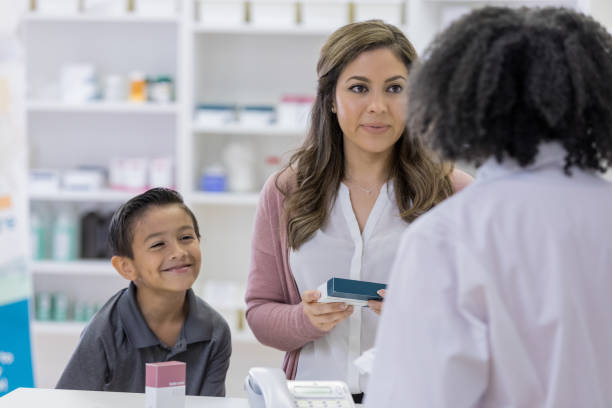 istock Young boy makes friends with pharmacist while mom asks questions 1153885302